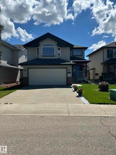 Two-story residence featuring light gray siding with dark trim, a prominent bay window with an arched transom, an attached two-car garage, and a covered front porch entry - 8507 179 Avenue, Edmonton, AB 