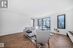 Spacious interior with extensive light-colored walls and wood-finish flooring in a herringbone pattern - 
