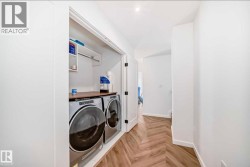 Dedicated laundry area featuring a front-loading washer and dryer, wood-finish countertop, and integrated shelving - 