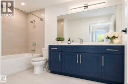Bathroom featuring a deep blue vanity with integrated storage, a rectangular undermount sink, and a spacious wall-mounted mirror - 