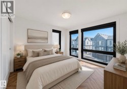 Spacious room featuring multiple large windows with black frames, wood-finish flooring in a herringbone pattern, and a built-in closet with a sliding barn door - 