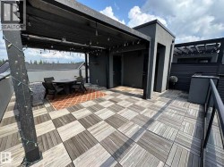 Expansive rooftop terrace featuring a patterned wood-finish tile floor - 