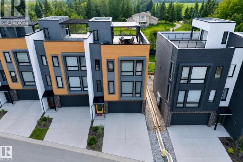 Contemporary townhome exteriors featuring multi-toned siding, integrated garages, and private driveways - 1304 Rutherford Road, Edmonton, AB 