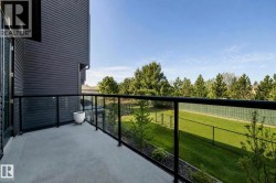 Private balcony with concrete flooring, black frame glass railing, and dark gray horizontal siding - 