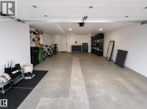 Spacious garage featuring a concrete floor, white painted walls, recessed lighting, and a white paneled ceiling - 1304 Rutherford Road, Edmonton, AB 