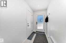 Entryway featuring a white door with frosted glass, recessed lighting, and white tile flooring - 