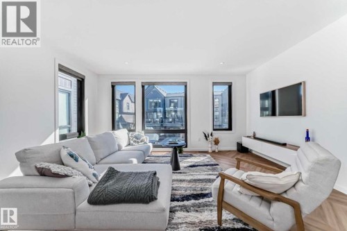 Open-concept living space featuring high ceilings and wood-finish flooring with a herringbone pattern - 1304 Rutherford Road, Edmonton, AB 