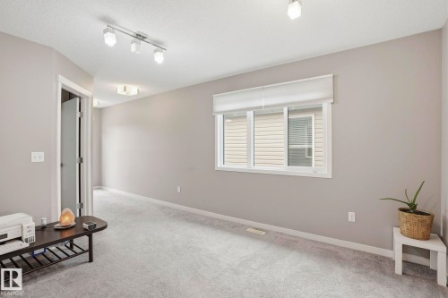 Bright interior space featuring light grey walls, white trim, and a window with white blinds - 4320 Annett Common, Edmonton, AB - Indoor Photo Showing Other Room