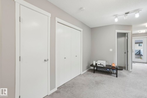 Hallway featuring light gray wall paint, white trim, track lighting, and gray carpet flooring - 4320 Annett Common, Edmonton, AB - Indoor