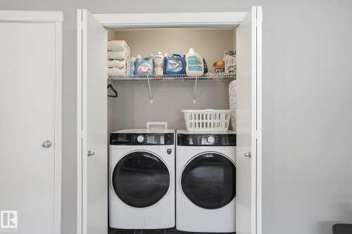Dedicated laundry closet featuring a stacked washer and dryer, wire shelving, and bi-fold doors - 4320 Annett Common, Edmonton, AB - Indoor Photo Showing Laundry Room