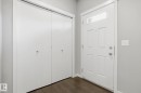 Entryway featuring a paneled door with transom window, bifold closet doors, light gray wall paint, white trim, and wood-finish flooring - 4320 Annett Common, Edmonton, AB  - Indoor Photo Showing Other Room 