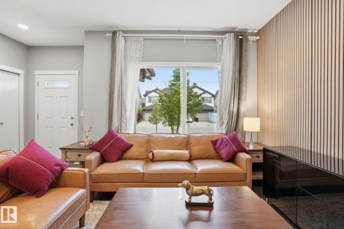 Bright living area featuring a large window, a paneled accent wall, and recessed ceiling lighting - 4320 Annett Common, Edmonton, AB - Indoor Photo Showing Living Room