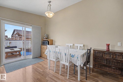 Dining area featuring wood-finish flooring, a contemporary pendant light fixture, and neutral wall tones - 19039 47 Avenue Nw, Edmonton, AB - Indoor Photo Showing Other Room