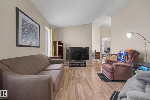 Spacious living area featuring wood-finish flooring and vaulted ceilings - 19039 47 Avenue, Edmonton, AB 