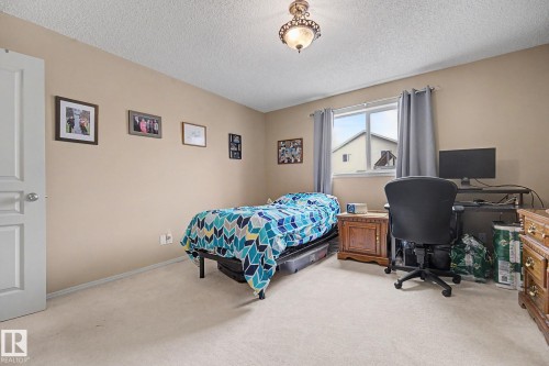 Carpeted room featuring a single window with curtain rods, a ceiling-mounted light fixture, and a solid white door - 19039 47 Avenue, Edmonton, AB 