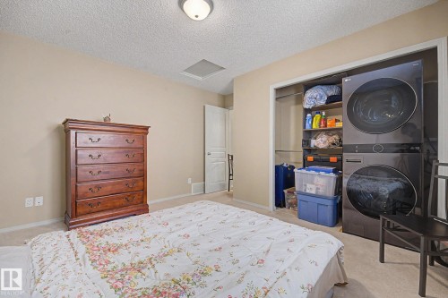 Integrated laundry closet featuring a stacked washer and dryer unit - 19039 47 Avenue, Edmonton, AB 