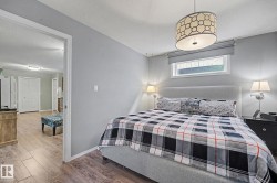 Light gray walls featuring a geometric drum pendant light fixture and a horizontal window with a roller shade - 