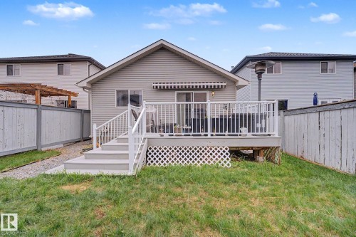 Rear exterior featuring a large elevated deck with white railings, a sliding glass door, and a retractable awning - 19039 47 Avenue, Edmonton, AB 