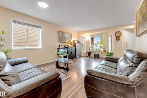 Spacious living area featuring wood-finish flooring, recessed lighting, a bay window, and light-colored walls - 312 Beringer Crescent, Edmonton, AB 