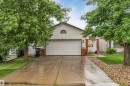 Siding exterior with brick accents, featuring a two-car garage and a paved driveway - 312 Beringer Crescent, Edmonton, AB 