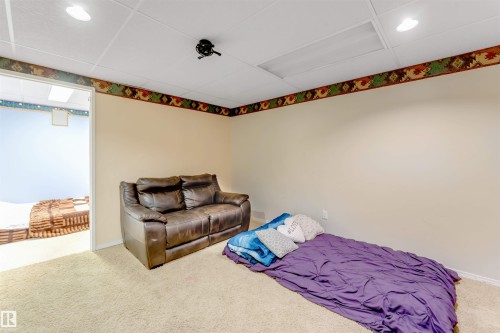 Carpeted room featuring a drop ceiling with recessed lighting and a decorative border - 312 Beringer Crescent, Edmonton, AB 