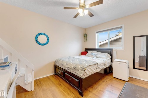 Room featuring wood-finish flooring, a window with exterior views, and a ceiling fan with integrated lighting - 312 Beringer Crescent, Edmonton, AB 