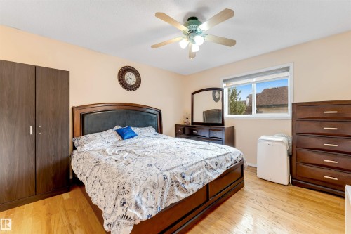 Spacious room featuring wood-finish flooring, a window offering natural illumination, and a ceiling fan with integrated lighting - 312 Beringer Crescent, Edmonton, AB 