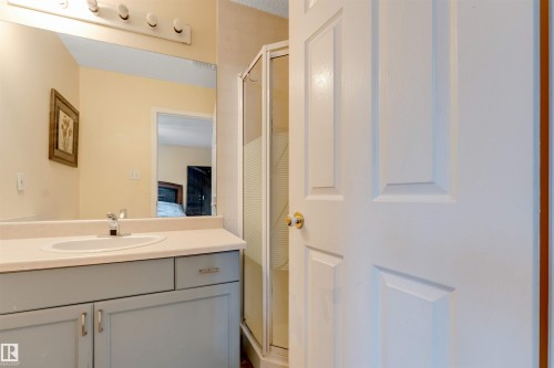 Bathroom vanity with light gray cabinetry, an integrated sink, and a chrome faucet - 312 Beringer Crescent, Edmonton, AB 
