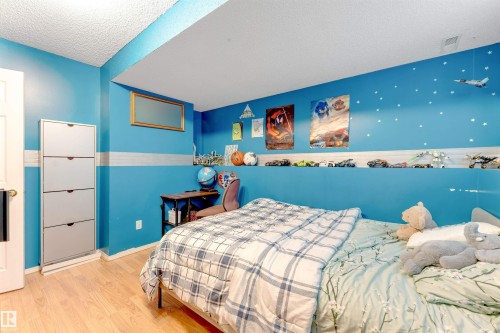 Light wood-finish flooring complements the vibrant wall color in this room - 312 Beringer Crescent, Edmonton, AB 