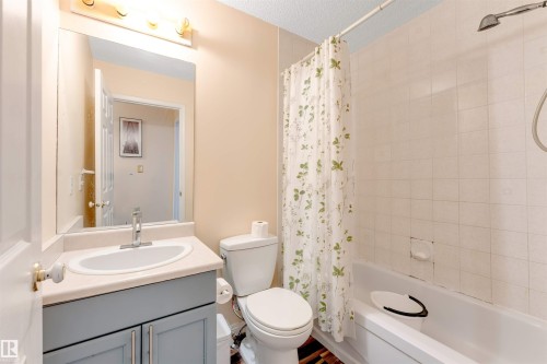 Bathroom featuring a vanity with a light-colored countertop, an undermount sink, and a two-door cabinet - 312 Beringer Crescent, Edmonton, AB 
