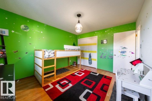 Interior room featuring wood-finish flooring, a pendant light fixture, and two panel doors - 20 Chippewa Rd, Leduc, AB 