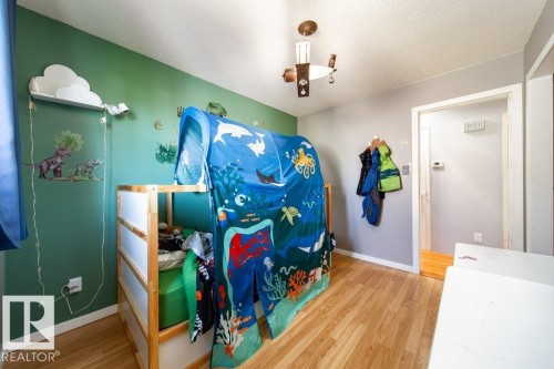 Room featuring light wood-finish flooring, a contemporary ceiling fan, and a painted accent wall - 20 Chippewa Rd, Leduc, AB 