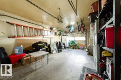 Spacious garage featuring concrete flooring and exposed ceiling beams - 
