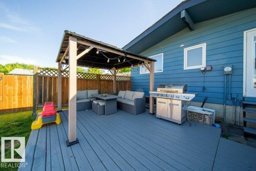 Spacious outdoor deck featuring a gazebo, string lighting, and a full privacy fence - 20 Chippewa Rd, Leduc, AB 