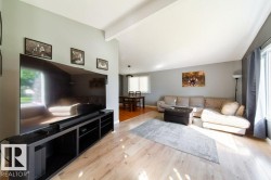 Open concept living area featuring wood-finish flooring, light grey wall paint, and white trim - 
