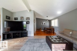 Living area featuring wood-finish flooring, vaulted ceiling, and neutral wall tones - 