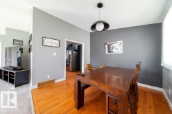 Dining area featuring wood-finish flooring and a contemporary pendant light fixture - 