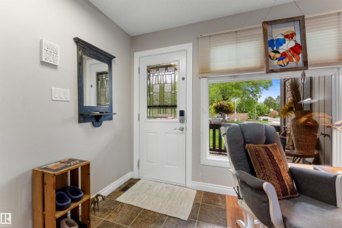 Entryway with a white door featuring decorative glass inserts and an electronic keypad - 5802 172 Street, Edmonton, AB 
