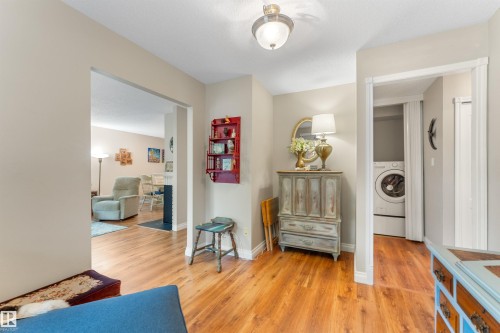 Hardwood-finish flooring throughout, featuring a recessed laundry area with a stacked washer and dryer - 5802 172 Street, Edmonton, AB 
