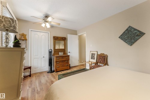 Bedroom featuring wood-finish flooring, neutral wall paint, and a ceiling fan with integrated lighting - 5802 172 Street, Edmonton, AB 