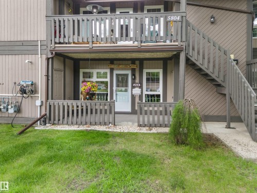 Exterior featuring a second-story balcony with railings, a ground-level covered porch with railings, and an exterior staircase providing upper-level access - 5802 172 Street, Edmonton, AB 