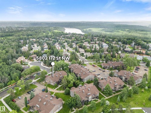 Aerial perspective showcasing the residential community, characterized by numerous brown-roofed structures and surrounding green spaces - 5802 172 Street, Edmonton, AB 