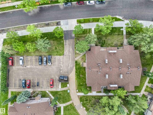 Aerial view showcasing a residential building with a brown shingle roof, surrounded by mature trees and green spaces - 5802 172 Street, Edmonton, AB 
