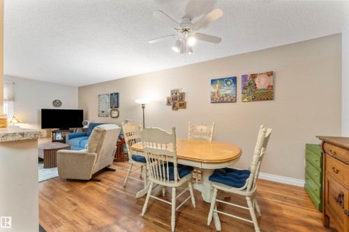 Dining area featuring wood-finish flooring, a ceiling fan with light fixture, and neutral wall tones - 5802 172 Street, Edmonton, AB 