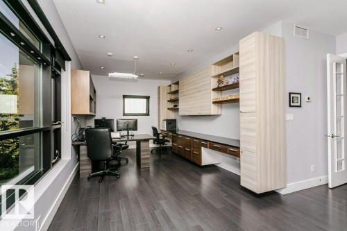Hardwood flooring with a gray finish, custom built-in cabinetry, modern lighting, recessed ceiling lights, and multiple windows - 9035 Saskatchewan Drive, Edmonton, AB 