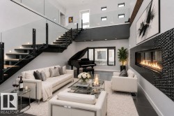 Open-concept living area featuring a linear fireplace with a mosaic tile surround, a floating staircase with glass railings and wood-finish treads, and dark tile flooring - 