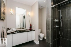 Bathroom featuring a floating vanity with a dark countertop and vessel sink, illuminated by twin sconces - 