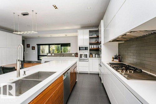 Modern kitchen featuring a gas range, stainless steel appliances, and a double basin sink - 9035 Saskatchewan Drive, Edmonton, AB 