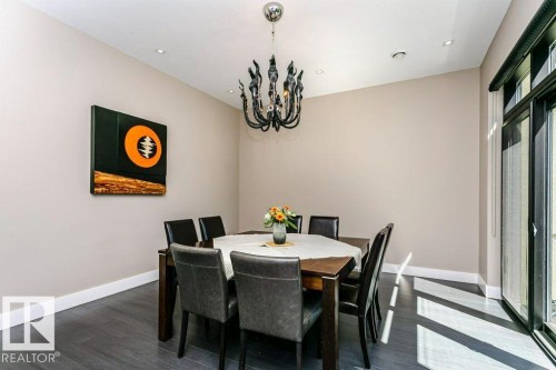 Dining space featuring wood-finish flooring, recessed lighting, and a dark-toned chandelier - 9035 Saskatchewan Drive, Edmonton, AB 