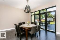 Spacious room featuring dark wood-finish flooring and a contemporary chandelier - 